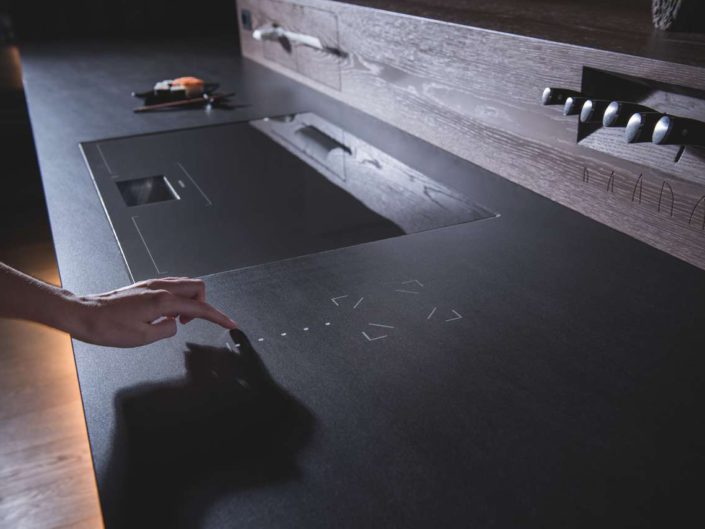 Mit STRASSER TOUCH STONE ist es erstmals möglich, direkt über die Küchenarbeitsplatte unterschiedliche Funktionen im Smart Home (Licht, Beschattung, Ton, etc.) einfach mit einer Berührung zu bedienen. Foto: STRASSER Steine
