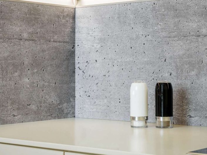 Coole Nischenlösung: Diese Rückwand sieht mit ihren natürlichen Luft-einschlüssen aus wie echter Beton und fasst sich auch so an. Dabei handelt es sich um eine perfekte Reproduktion. Foto: AMK