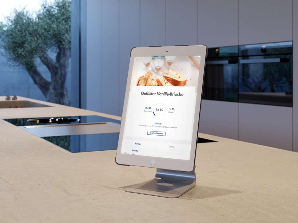 Die Einbaugeräte in den neuen Lifestyle-Wohnküchen sind vernetzt, denn heutzutage wird smart gekocht. Dabei hat man zum Beispiel sein Tablet mit den Schritt-für-Schritt-Anleitungen im Blick. Foto: AMK