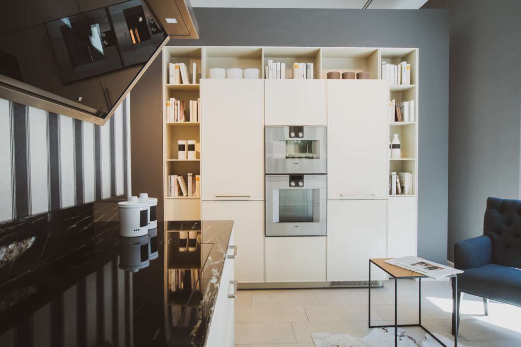 Country bedeutet nicht gleich rustikal. Der dezente, sandfarbene Mikrostrukturlack und die offenen Stauraummöglichkeiten geben diesem Landhausküchen-Design einen modern-puristischen Look. Die Integration von Einbaugeräten in die Schrankfronten lockert das Bild auf, so dass die WARENDORF Country selbst in zeitgemäßen Loft-Apartments wirkungsvoll in Szene gesetzt werden kann. Foto: Warendorf Küchen