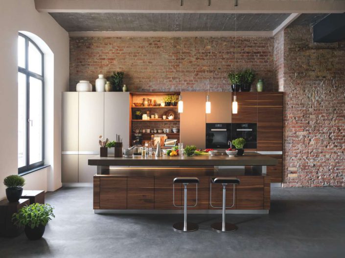 Herzstück der k7 Küche ist die stufenlos von 74 bis 114 cm höhenverstellbare Kochinsel. Über das flächenbündig eingearbeitete Bedienelement lässt sich die Arbeitsplatte so immer exakt auf die individuellen ergonomischen Bedürfnisse einstellen. Foto: Team7 Küchen