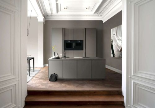 Ein Küchentraum, der prächtige Hamburger Altbau gepaart mit einer kompakten, puristischen SieMatic Küchenplanung mit feinen 6,5 mm-Rahmenfronten in Mattlack Umbra. Hinter seitlich einschiebbaren Türen der mittleren Hochschränke verbergen sich dezent die E-Geräte, wenn sie nicht benötigt werden. © Copyright SieMatic