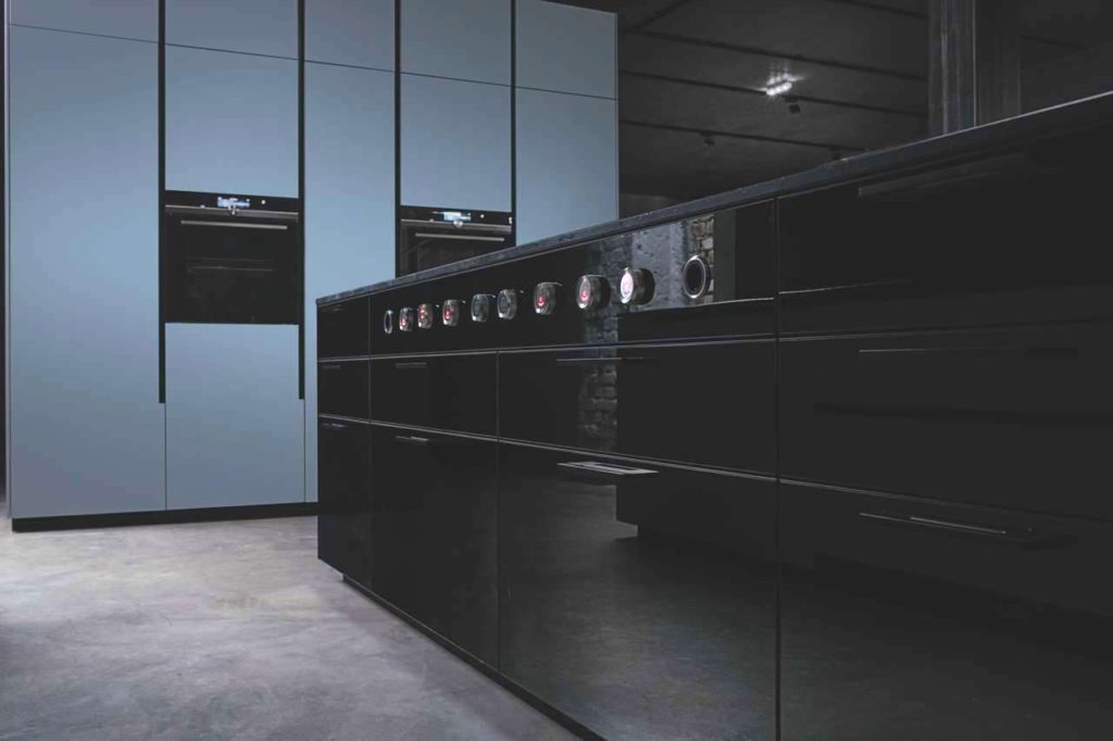 Das Geheimnis der speziellen Ästhetik liegt in dem schwarz lackierten, reflektierenden Dekorglas. Oberschränke und Kücheninsel werden mit ihrer schimmernden Oberfläche und den faszinierenden Spiegelungen zum Blickfang. Foto: ewe