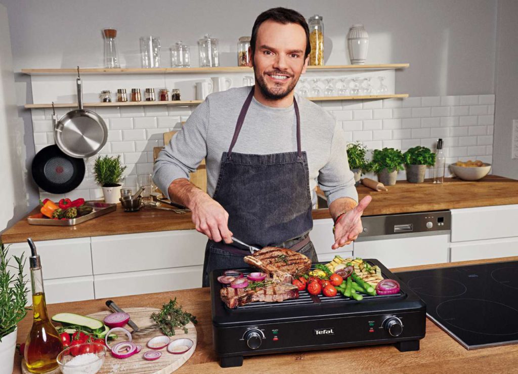 Steffen Henssler grillt auf dem neuen Tefal Smokeless Indoor Grill. Foto: Tefal