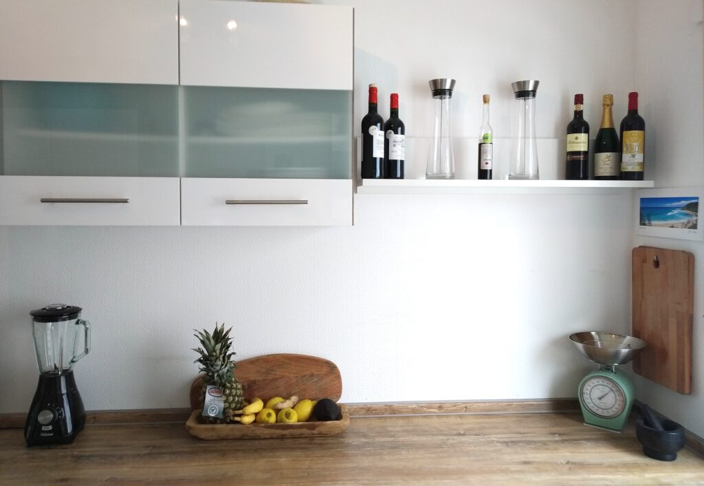 Ein schmales Wandregal bietet auch noch Platz für die schönen Dinge im Leben und lockert die Optik der Küche auf. Foto: Küchen Journal