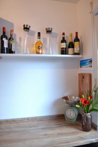 Ein schmales Wandregal bietet auch noch Platz für die schönen Dinge im Leben und lockert die Optik der Küche auf. Foto: Küchen Journal