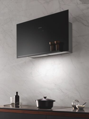 Zieht alle Blicke auf sich: Mit geringer baulicher Tiefe und reduziertem Design fügt sich die neue Wandhaube DA 9090 W Screen in jedes puristische Küchenumfeld ein. Hier in der Farbe Obsidianschwarz Foto: Miele