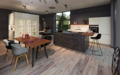 Design, Genuss, Funktion: Der weiße Solitär mit den Vitrinenschränken sieht nicht nur gut aus. Darin lässt sich auch sehr viel unterbringen. Zudem sorgt er für Transparenz und dient als praktischer Raumteiler. Foto: AMK 