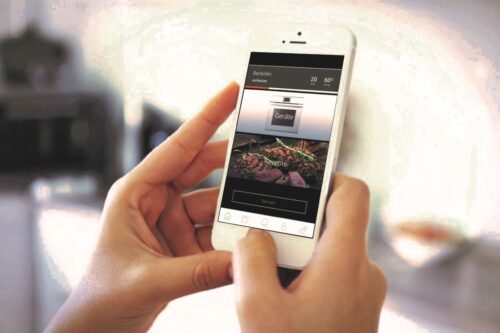 Statt ihr Smartphone beim Kochen wegzulegen, nutzen Männer es viel lieber für anspruchsvolle Rezepte und das direkte Ansteuern der Küchengeräte. Foto: AMK