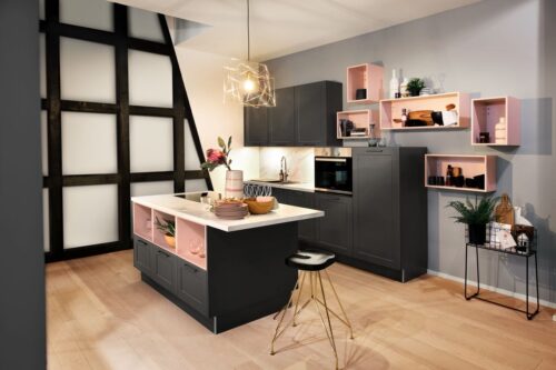 Das „Graphit“ strahlt durch die Regalelemente in der Farbe „Lotus“ Leichtigkeit aus – die Küche von Häcker in Rosa und Grau. Foto: Häcker Küchen