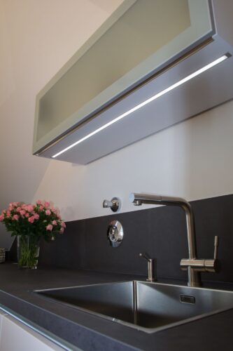 Der dezente Lichtstreifen unter dem Hängeschrank sorgt für mehr Helligkeit auf der Arbeitsfläche. Foto: Küchen Journal