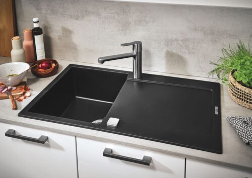 Integriert in die hellgraue Arbeitsfläche ist die Spüle von Grohe in „Granit Schwarz“ ein Eyecatcher. Foto: Grohe