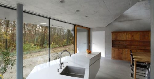 Licht und Bäume spiegeln sich in der glänzend-weißen Oberfläche aus Silestone® Blanco Zeus Extreme. Foto: Philippe Wiget für DALUZ GONZALEZ ARCHITEKTEN