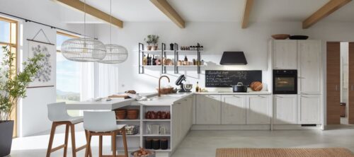 Das gekalkte Holz wirkt hier ganz natürlich und rustikal. Modern dazu: Das Metallregal, die Armatur und viele hübsche Accessoires. Foto: Bauformat