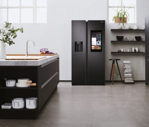 Die schwarzen Möbel werden durch die weiße Wand und vor allem die weißen Details, wie zum Beispiel die Töpfe im Regal, betont. Die Kühlschrankkombination in matter Optik ist von Samsung. Foto: Samsung