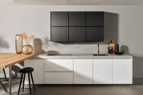 Die Serie „Colors“ von SieMatic hat eine moderne Optik. Das Zusammenspiel von Schwarz und Weiß wird hier von Weiß dominiert. Eine schöne Auflockerung ist die Holzplatte. Foto: SieMatic