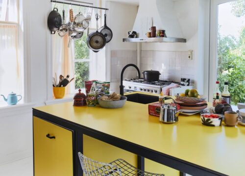 Küche im Retro-Look: Das zarte Gelb dominiert und wird durch schwarze und weiße Akzente betont. Teekanne „Bold“ in Silber von HKliving, zu kaufen über Car Möbel. Foto: Car Möbel