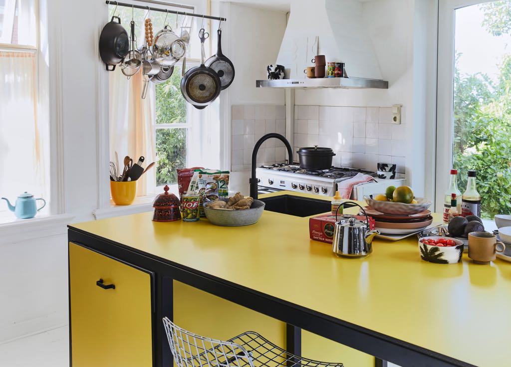 Küche im Retro-Look: Das zarte Gelb dominiert und wird durch schwarze und weiße Akzente betont. Teekanne „Bold“ in Silber von HKliving, zu kaufen über Car Möbel. Foto: Car Möbel