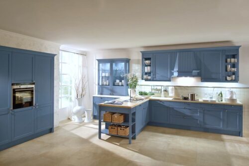 Mit der Landhausküche „Bristol“ in Achatblau von Häcker kommt Frische ins Zuhause. Die Küche aus Eschenholz hat tolle Details, wie die halboffene Insel oder den Vitrinenschrank. Foto: Häcker