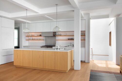 Ganz im reduzierten Skandi-Stil ist diese Küche konzipiert. Die symmetrisch angeordneten Bretter beherbergen dekorative Kleinigkeiten. Küchenboden von Mafi. Foto: mafi / Beatrice Pediconi