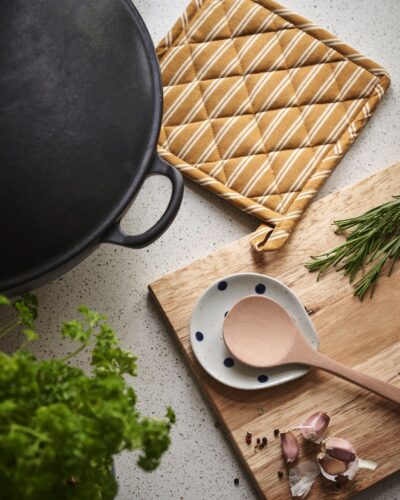 Ein solcher Topflappen hilft und macht sich optisch gut in der Küche. Dekorativ ist die Herbstfarbe Senf, von Sostrene Grene.