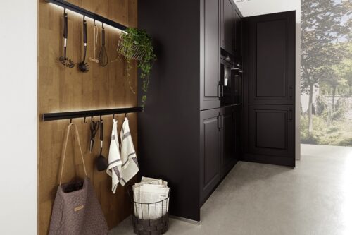 So praktisch ist das beleuchtete Relingsystem und sieht noch dazu sehr stylisch aus. Die Wand in Holz ist ein wahrer Hingucker. Sie sorgt für eine besondere Atmosphäre in der schlichten schwarzen Küche. Aus der Serie „Sylda“ von Mondo.