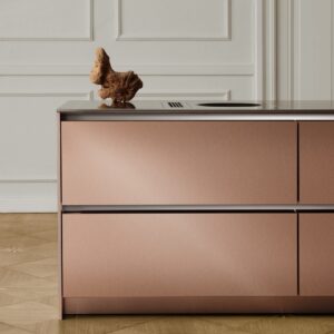 Durch das matte Roségold wirkt die Küche „S2“ von SieMatic regelrecht verspielt und passt schön zur Jugendstilarchitektur des Raumes. Auch die Arbeitsplatte aus kaltgewalztem Edelstahl hat die gebürstete Optik.