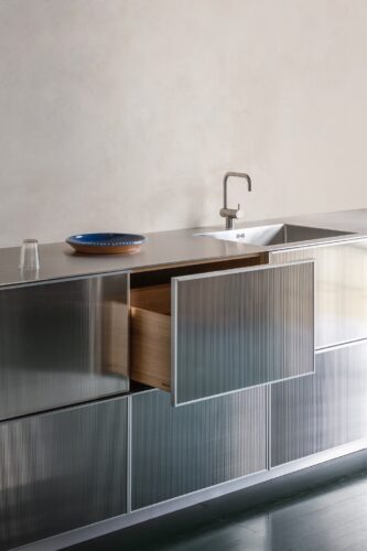 Die Marke Reform stellt mit „Reflect“ ein neues Küchenprogramm vor. Es wurde gemeinsam mit dem französischen Architekten Jean Nouvel designt. Die Fronten beschreiben mit ihrem unbehandelten Metall eine Extravaganz im Art-Déco-Stil. Charakteristisch sind die vertikalen Rillen, die einen tollen Spiegeleffekt haben.