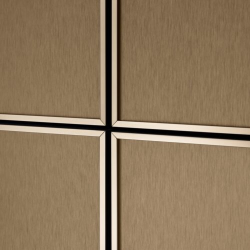 Ein ausschlaggebendes Detail bei der Küche aus Holz von SieMatic sind die goldfarbenen Kanten, die die Fronten zugleich betonen und strukturieren.