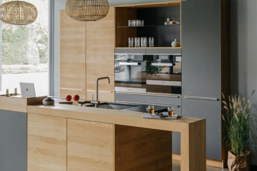 Der Cube in „Eiche Natur“ ist in die Arbeitsplatte eingesetzt und dient als Ablagefläche. Zum Beispiel für Tabletts, auf denen man sich Rezepte anzeigen lässt. Auch ein Kräutertopf hätte hier Platz. Küche aus Naturholz von Walden
