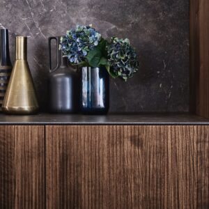 Das Modell „Bossa“ von Leicht ist ein wirkliches Architektur-Statement mit seiner Echtholzfront aus Walnuss. Es begeistert durch seinen Streifenlook und das edle dunkle Braun. Credit: Leicht/ P. Schumacher  