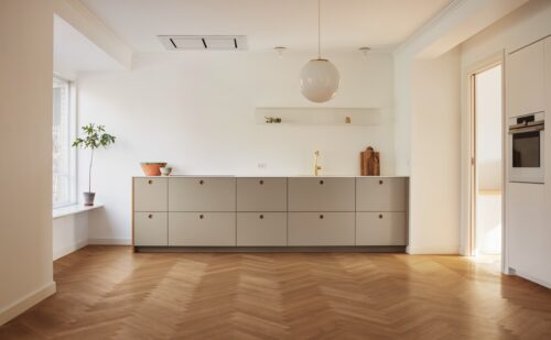 Küchenmodell BASIS mit Linoleum-Fronten in der Farbe Pebble und Griffen in Eiche Natur. Die Arbeitsplatte ist aus Corian. Alles von Reform Copenhagen.