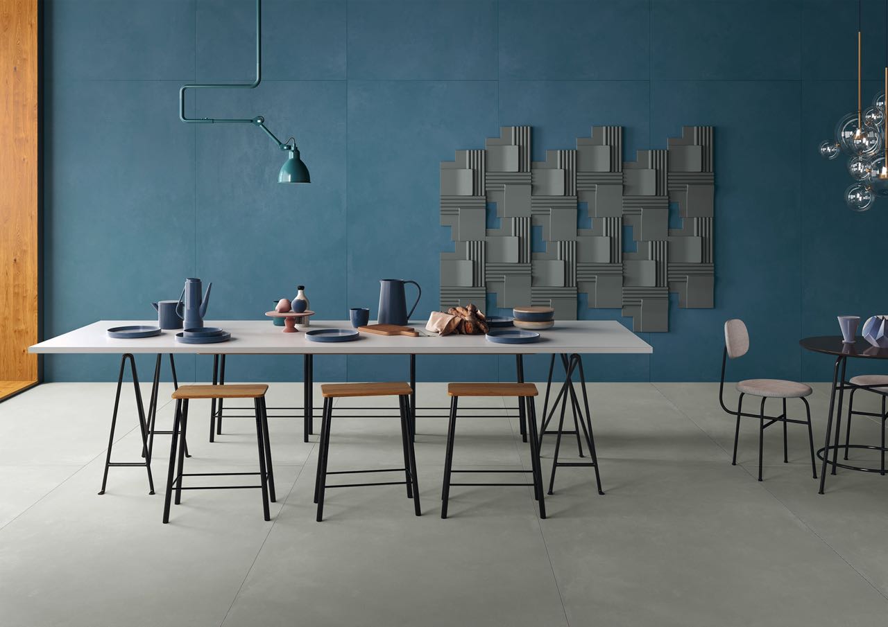 Die Farbe Weiß für den Tisch ist klassisch, das Gestell und die Stühle haben eine moderne, filigrane Note. Außergewöhnlich ist die Wandgestaltung, die ein regelrechtes Kunstwerk ist. Das Design “Rilievi” ist designt von Florim. 