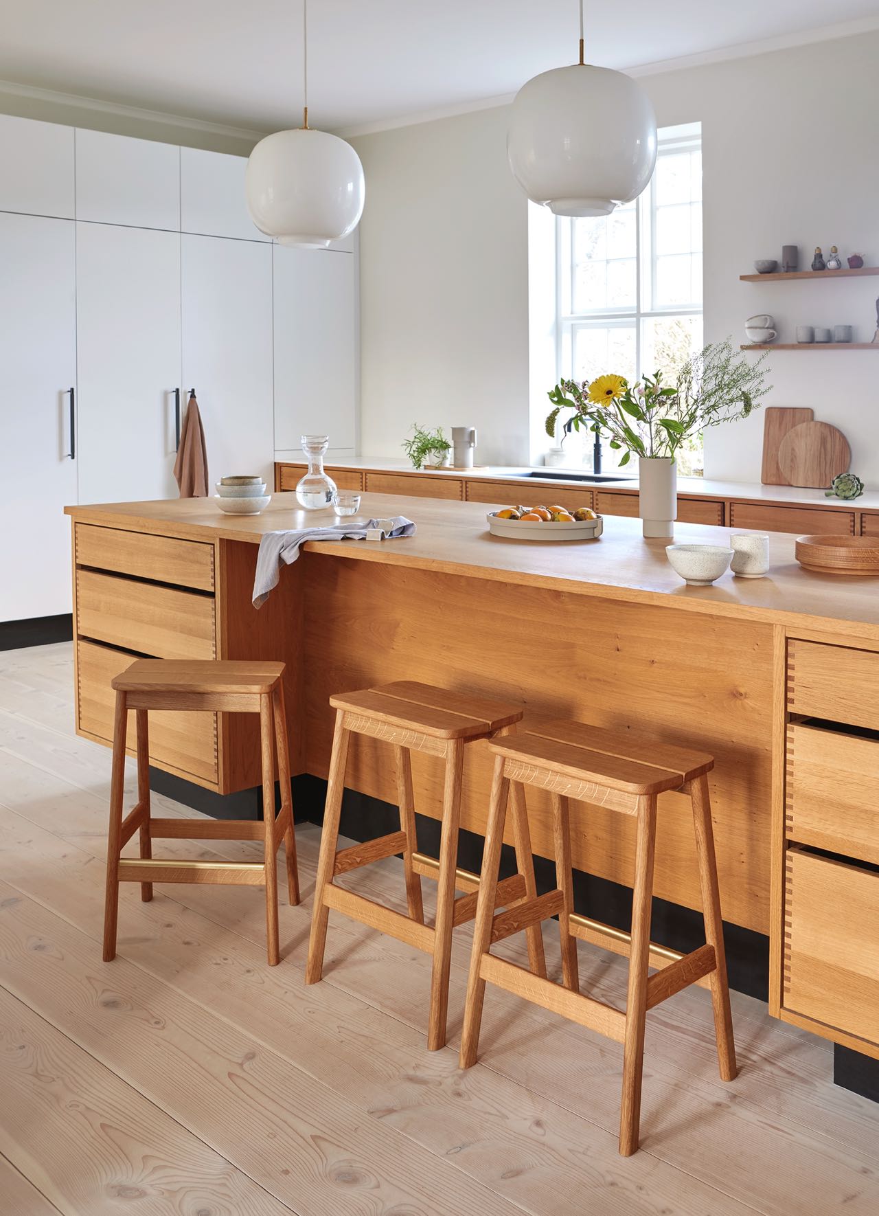 Nachhaltige Möbel, auch für die Küche, findet man beim Label Form & Refine. Ein regelrechtes Statement sind die üppigen weißen Leuchten über der Arbeitsplatte.