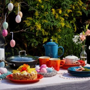 Hier ist ja richtig was los und es wurde nicht an Farbe gespart! Reichlich Geschirr, Eier und Blüten tummeln sich da. Auch der Kuchen mit Blüten sorgt für Stimmung. Und wenn dann noch die Sonne scheint, fühlen sich Familie und Freunde gleichermaßen wohl. Alles von Le Creuset.