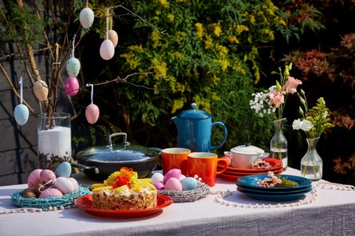 Hier ist ja richtig was los und es wurde nicht an Farbe gespart! Reichlich Geschirr, Eier und Blüten tummeln sich da. Auch der Kuchen mit Blüten sorgt für Stimmung. Und wenn dann noch die Sonne scheint, fühlen sich Familie und Freunde gleichermaßen wohl. Alles von Le Creuset.