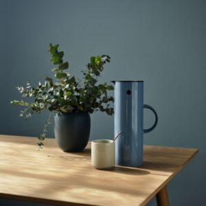 Die Thermoskanne von Stelton im Farbton „Dusty Blue” harmoniert perfekt zur gleichfarbigen Wand. Das Ambiente ist skandinavisch wohnlich.