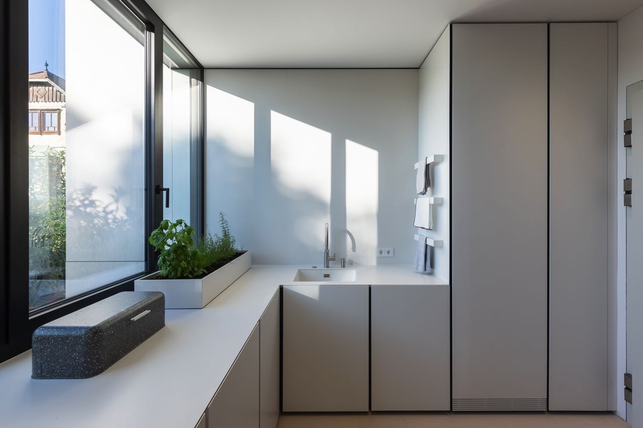 Arbeitsflächenerweiterung mit verborgenen Kühlschränken und zweitem, kleinerem Spülbecken. Foto: Schmid Baugruppe Holding GmbH, 2021
