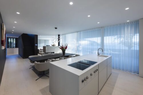 Harmonisch abgestimmter Wohn-, Koch- und Essbereich mit direktem Zugang zur halbüberdachten Terrasse. Foto: Schmid Baugruppe Holding GmbH, 2021