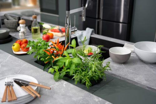 Gemüse in einer Schüssel zu waschen reduziert Wasser. Tipp: Auch der eigene Kräuteranbau ist nachhaltig! Küche von Schmidt Küchen.