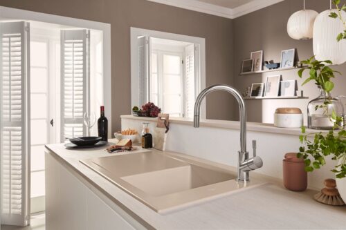 Lamellentüren und die sandfarbe Spüle bringen eine besondere Note in den Raum. Spüle und Armatur von Villeroy & Boch.