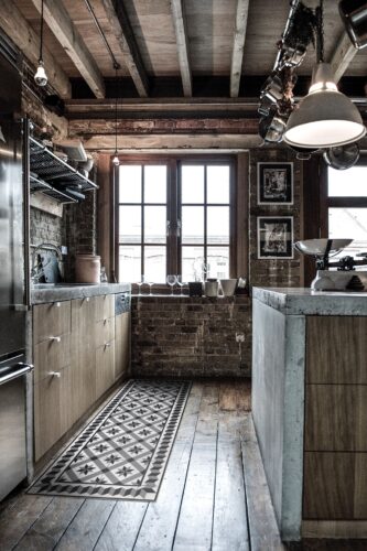 Holzbalken, Holzboden, Arbeitsplatte aus Stein – hier ist vieles zu beobachten, was südlichen Charme verbreitet. Niedlich ist die Vinylmatte „Gothic“ von Beija Flor. Mit ihr kann man ein bisschen schummeln und sie einfach dahin legen, wo man den sie optisch benötigt. Von Car Möbel.