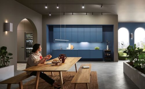 Diese Küche fällt garantiert nicht aus dem Rahmen, denn sie ist fest in ihn eingebaut. Noch verstärkt wird der Effekt durch die Farbharmonie zwischen Küchenfronten und Wandgestaltung, beides in verspieltem Himmelblau. Von next125.