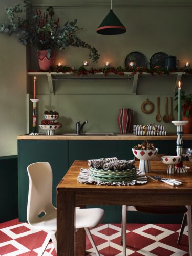  Typische Weihnachtstöne finden sich in dieser Küche. Denn Wand, Fronten und Boden sind in Rot und Grün gehalten. Auch die adventliche Deko passt sich daran an. Eine tolle Idee ist die hübsche Girlande mit roten Beeren im Regal. Die Wandfarbe ist von Annie Sloan.