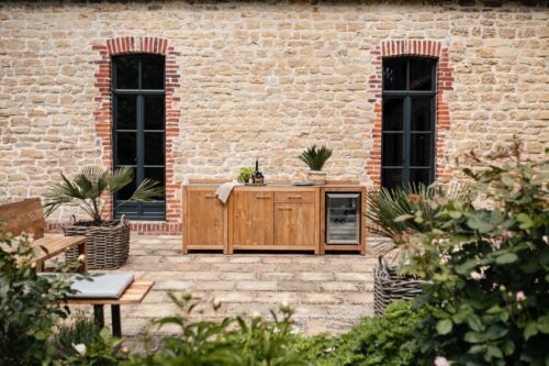 Ob eine Grillparty oder ein unkompliziertes Familien-Essen, die Outdoorküche von Niehoff Garden kommt sehr edel mit Teakholz und gebürstetem Edelstahl daher. Super praktisch ist das Kühlmodul inklusive Kühlschrank.