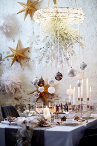 Die Verbindung aus Weiß und Gold kommt hier richtig gut zur Geltung. Die Elemente wie der Kerzenständer oder auch der opulente Kranz über dem Tisch machen den Look ganz besonders. Eine schöne Ergänzung: Papiersterne an der Wand. Alles von Depot.