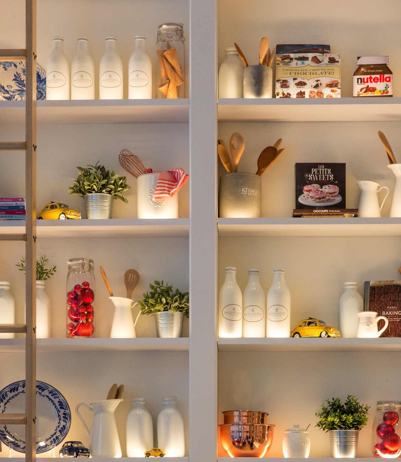 Weiße Keramikbehälter bilden die Basis in diesem schön ausgeleuchteten Küchenregal. Bunte Farbtupfer lockern die Komposition perfekt auf. Foto: Jason Leung | Unsplash