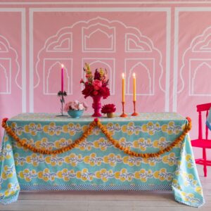 Mit einem Tischtuch kann man eine Tafel gleich aufwerten. Hier wurde quasi eine Art Stilleben geschaffen mit Kerzen und frischen Blumen und Girlanden. Stoff vom britischen Label Molly Mahon.