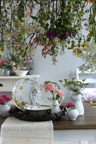 Blumen mal anders. Sie hängen von der Decken-Lampe herab und verschönern den Raum. Aber auch in den kleinen Vasen machen sie sich gut. Geschirr und Accessoires von Hutschenreuther.