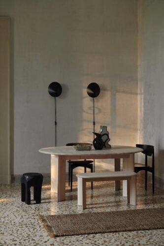 Praktisch zum Sitzen sind V-förmige Beine. Der ovale Tisch ist ausgezogen und hat eigentlich eine runde Silhouette. Alles von Ferm Living.